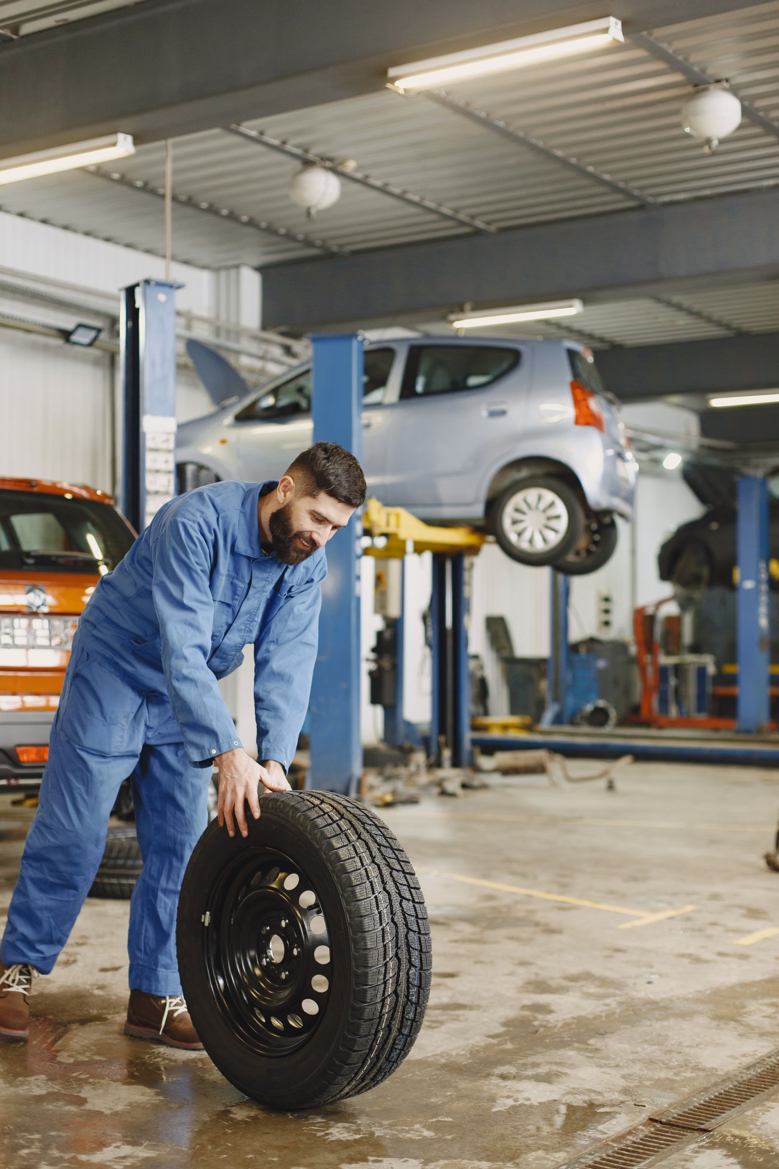 Mechanic rolling a wheel in the tire shop
