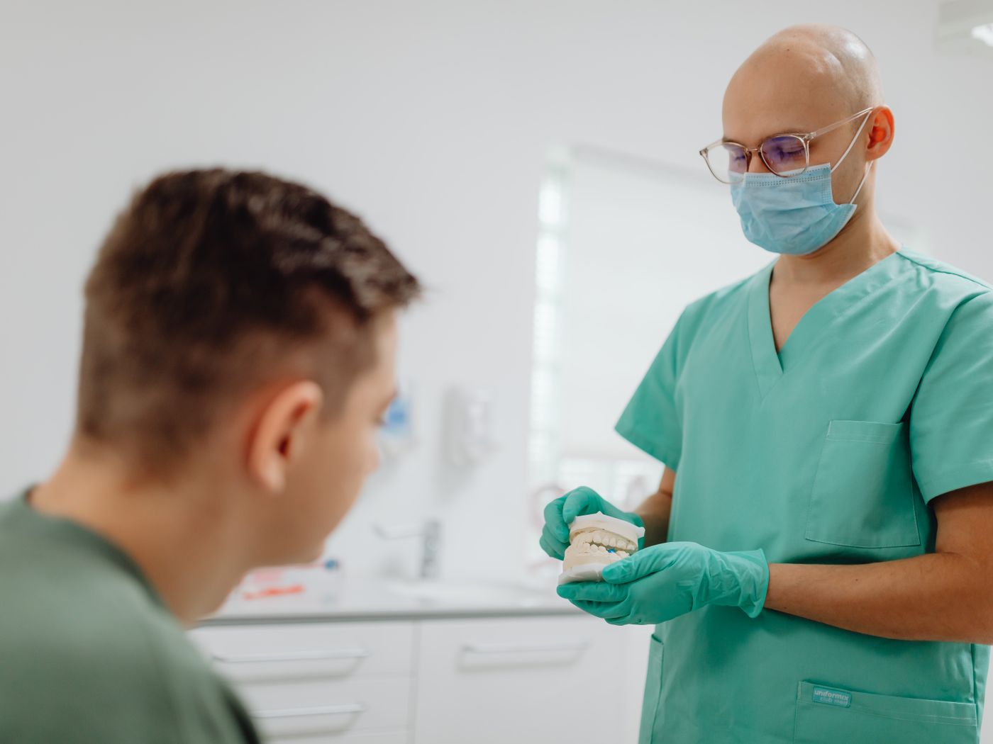 Dentist showing a jaw model to a patient